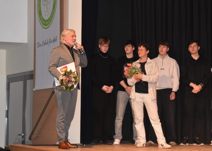 Gesamtschuldirektor Tjark Ommen hat Blumen und Süßigkeiten für alle dabei.