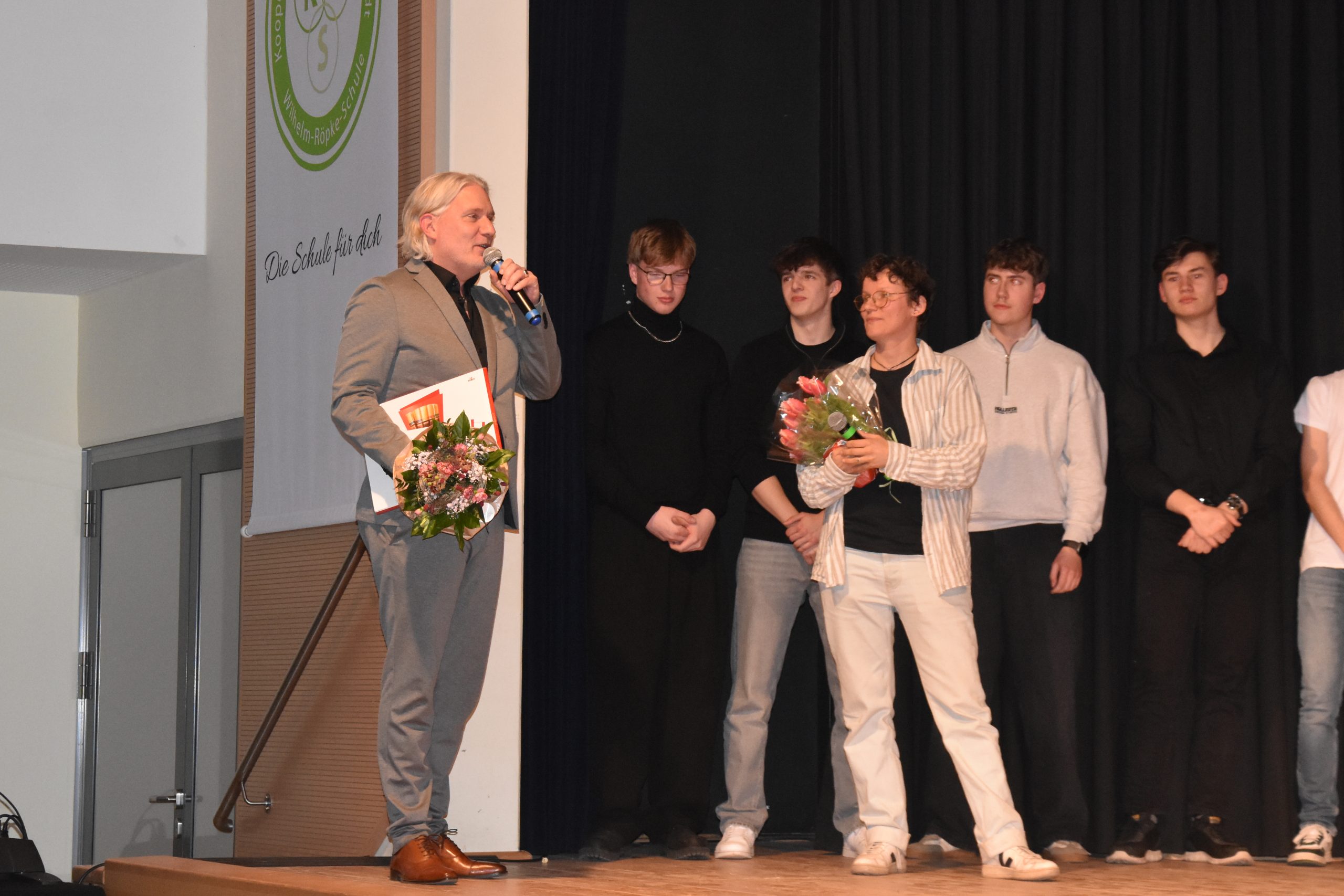 Gesamtschuldirektor Tjark Ommen hat Blumen und Süßigkeiten für alle dabei.